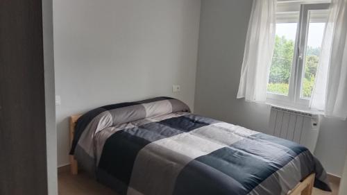 a bed in a bedroom with a window at Apartamento nuevo cerca de la costa y a 15 min de Bilbao! in Urduliz
