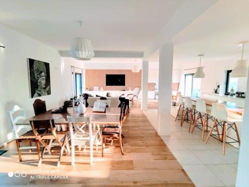 a dining room and living room with a table and chairs at Villa "A Vida é Linda Santa Luzia" in Santa Luzia