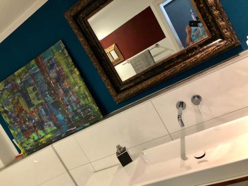 a mirror above a sink in a bathroom at Deichkind CityLoft in Bremen
