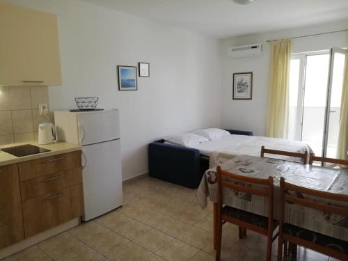 a bedroom with a bed and a kitchen with a table at Apartmani ROKO, Sevid in Marina