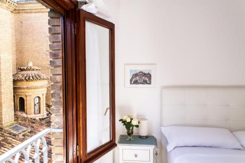 um quarto com uma cama e uma janela com vista em Apartamento con vistas en centro histórico em Zaragoza