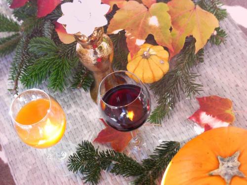 a glass of wine sitting next to a vase with a christmas centerpiece at Hotel Mariahilf München in Munich
