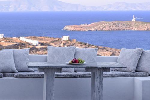 a table with a bowl of fruit on top of a balcony at Syros Luxury Living in Rózia