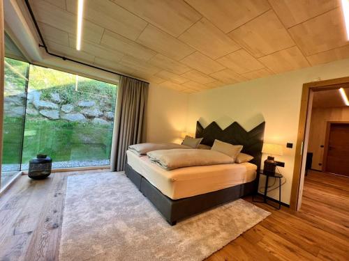 a bedroom with a bed and a large window at Chalet Annelies in Ramsau am Dachstein