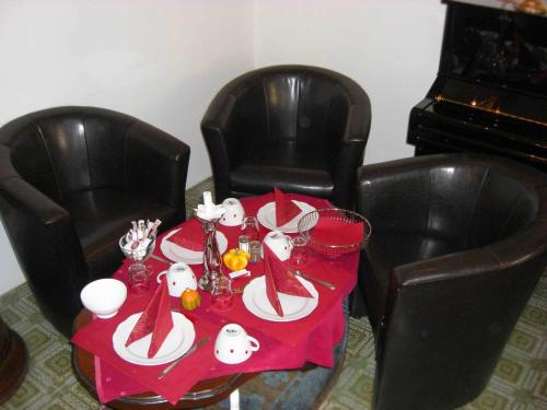 a table with a red table cloth on a table with chairs at Hotel Mariahilf München in Munich