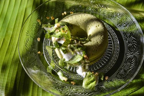 a glass bowl of salad on a green plate at Le Martin Boutique Hôtel in Cul de Sac