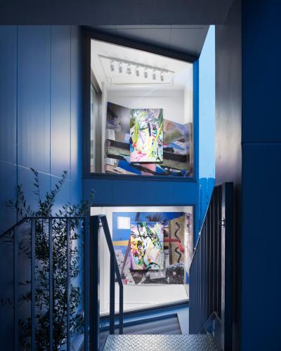 a hallway with blue walls and a blue staircase at BnA Alter Museum in Kyoto