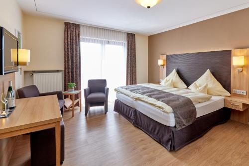 a hotel room with a bed and a desk at Hotel Sankt Maximilian in Bernkastel-Kues
