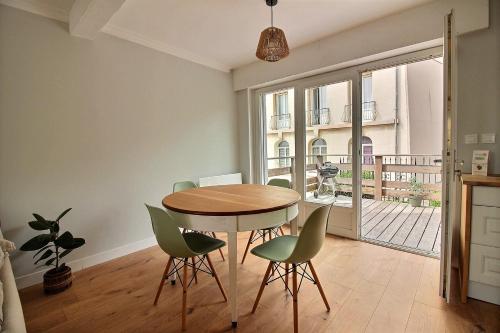 une salle à manger avec une table et des chaises vertes dans l'établissement Maison face à Nausicaa, à Boulogne-sur-Mer