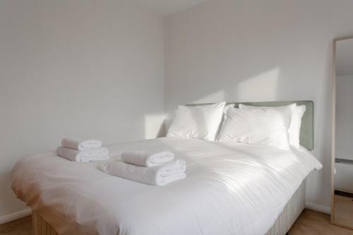 a white bed with towels on top of it at A Spacious 2 Bedroom Apartment In Aldgate East in London