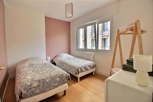 ein Schlafzimmer mit zwei Betten und einem Fenster in der Unterkunft Maison face à Nausicaa in Boulogne-sur-Mer