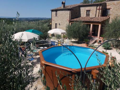 - une piscine extérieure en face d'une maison dotée d'un toit dans l'établissement Casale San Marco B&B, à Piccione