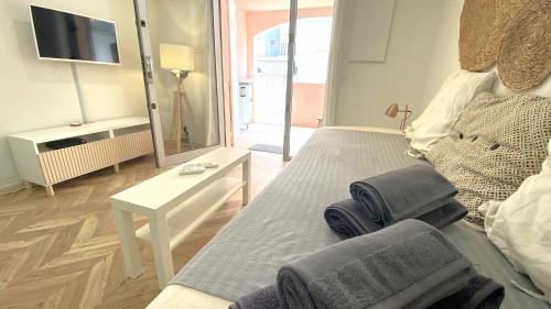 um quarto com uma cama, uma mesa e uma televisão em Studio Bricka - 200m to the beach, parking, clim, terrace em Antibes