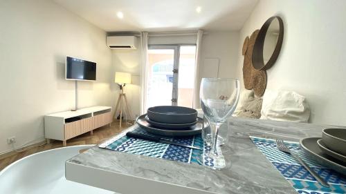 - une table avec des assiettes et un verre de vin dans l'établissement Studio Bricka - 200m to the beach, parking, clim, terrace, à Antibes