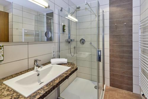 a bathroom with a sink and a shower at Hotel Sankt Maximilian in Bernkastel-Kues