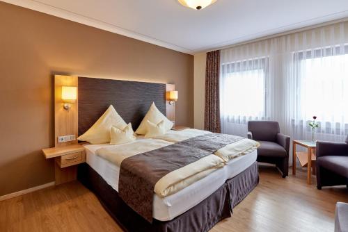 una habitación de hotel con una cama grande en una habitación en Hotel Sankt Maximilian, en Bernkastel-Kues