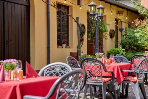 a group of tables and chairs with red table cloth at Hotel Sankt Maximilian in Bernkastel-Kues