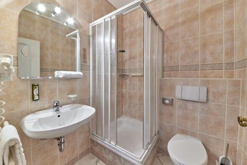 a bathroom with a shower and a sink and a toilet at Hotel Sankt Maximilian in Bernkastel-Kues