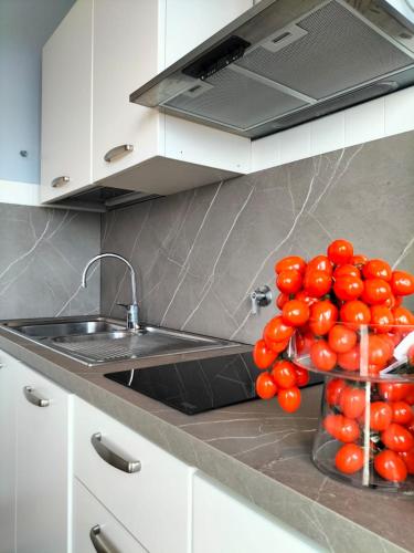 a bunch of tomatoes sitting on a counter next to a sink at Attico con vista mozzafiato in Bordighera