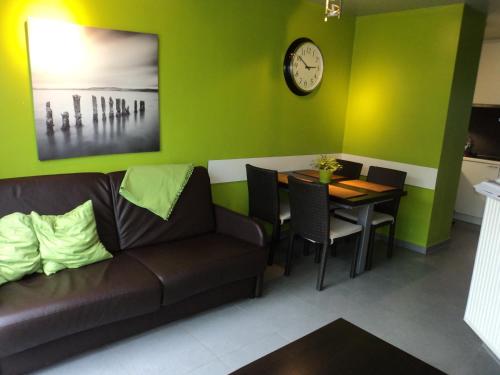 ein Wohnzimmer mit einem Sofa und einem Tisch mit einer Uhr in der Unterkunft For Ever in Nieuwpoort
