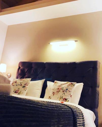 a bed with a black headboard with pillows at Grimani Pension in Nafplio