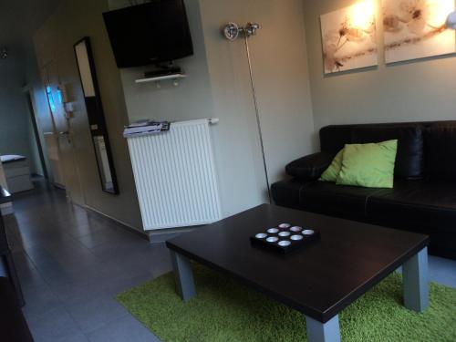 a living room with a black couch and a table at For Ever in Nieuwpoort