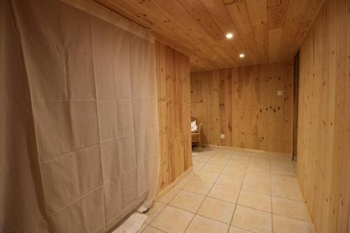 ein leeres Zimmer mit Holzwänden und Fliesenboden in der Unterkunft Maison face à Nausicaa in Boulogne-sur-Mer