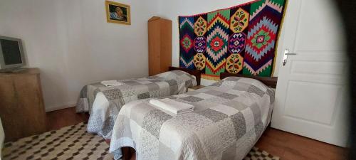 2 camas en una habitación con un cuadro en la pared en La Ionicã Rozavlea MM, en Rozavlea