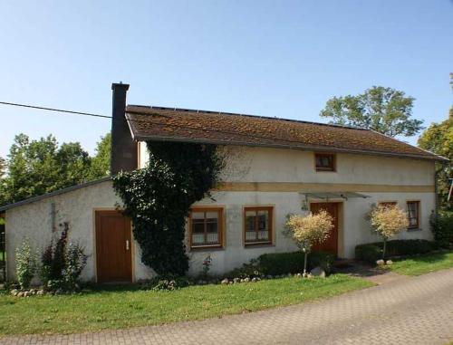 a small white house sitting on the side of a road at Rügen Fewo 287 in Kluis