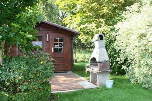 a small house with a stone oven in a yard at Rügen Fewo 287 in Kluis