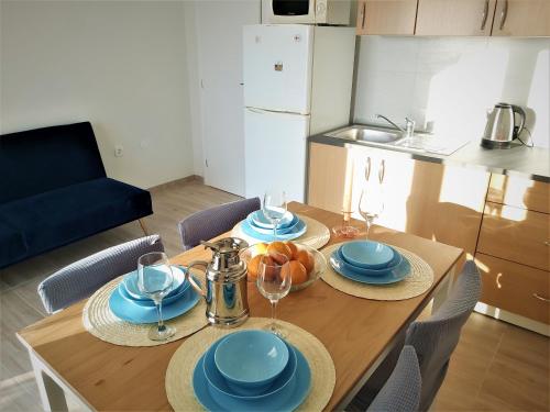 een keuken met een tafel met borden en wijnglazen bij Apartman Helena in Gradac