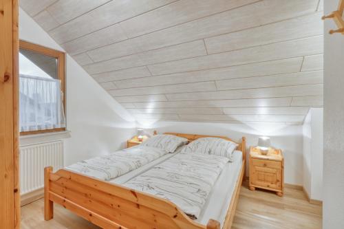 Cama en habitación con techo de madera en Ferienhaus Nina en Kirchheim