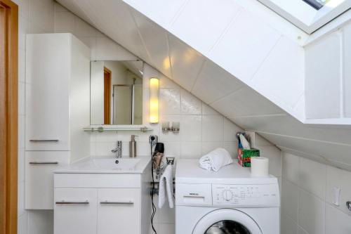 uma lavandaria branca com um lavatório e uma máquina de lavar roupa em Ferienhaus Viola em Kirchheim