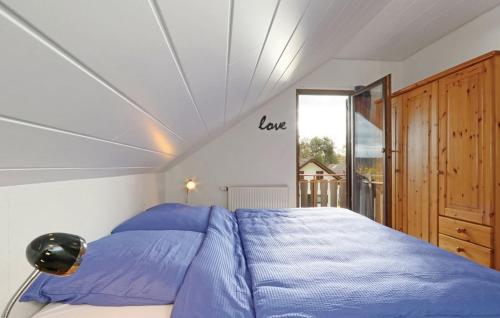 sypialnia z łóżkiem z niebieską pościelą i oknem w obiekcie Ferienhaus Zoe w mieście Kirchheim unter Teck