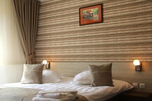 una camera d'albergo con letto a righe di Vila Creasta Cocosului a Păltiniş