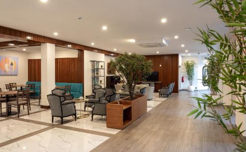 un hall avec des chaises et des tables dans un bâtiment dans l'établissement Hotel Afonso V & SPA, à Aveiro