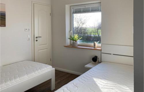 um quarto com 2 camas e uma janela em Nice Home In Niebll With Kitchen em Niebüll