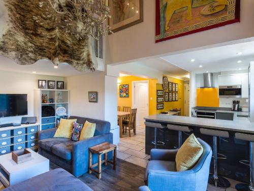 Il comprend un salon doté d'un mobilier bleu et une cuisine. dans l'établissement Ski-in/ski-out & pool: great for summer and winter, à Saint-Gervais-les-Bains