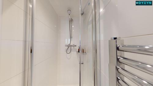 een douche met een glazen deur in de badkamer bij One Bed Apartment Newport - Garden - Parking - By DYZYN in Newport
