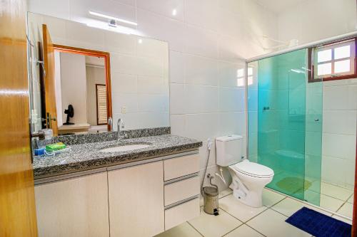 uma casa de banho com um WC e uma cabina de duche em vidro. em Casa Del Rey - cond. fechado Centro em Pirenópolis