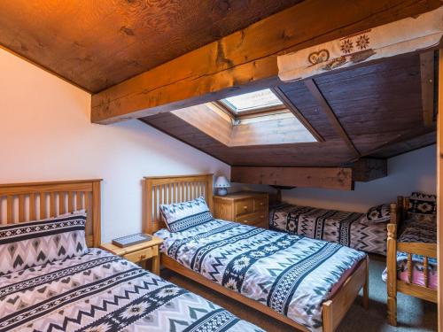 deux lits dans une chambre avec un plafond en bois dans l'établissement Ski-in/ski-out & pool: great for summer and winter, à Saint-Gervais-les-Bains