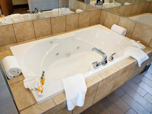 y baño con bañera grande y toallas. en Holiday Inn Purdue - Fort Wayne, an IHG Hotel, en Fort Wayne