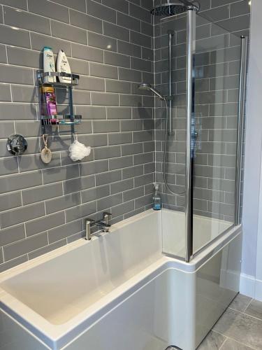 大托靈頓的住宿－Little Silver，浴室设有浴缸和淋浴。