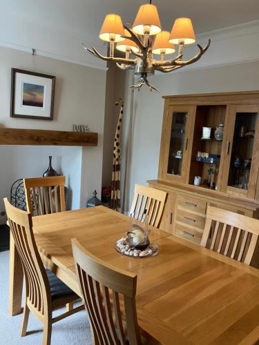 a dining room table with chairs and a chandelier at Little Silver in Great Torrington