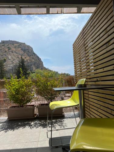 a table and a yellow chair on a patio at Grimani Pension in Nafplio