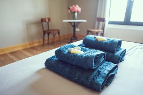 a pile of towels sitting on top of a bed at Domaine du lion rouge in Coucy-le-Château-Auffrique