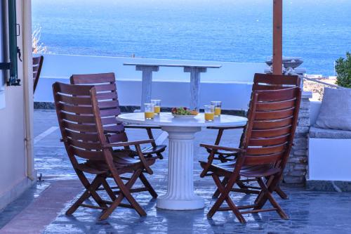 a table with two chairs and a table with drinks at Syros Luxury Living in Rózia
