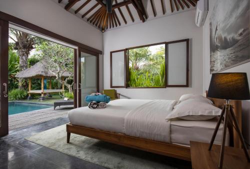 a bedroom with a large bed and a pool at Villa Markisa Echo Beach in Canggu