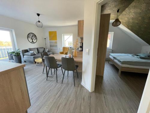 eine Küche und ein Wohnzimmer mit einem Tisch und Stühlen in der Unterkunft Moderne Wohnung mit Balkon inmitten der Lausitz in Bernsdorf