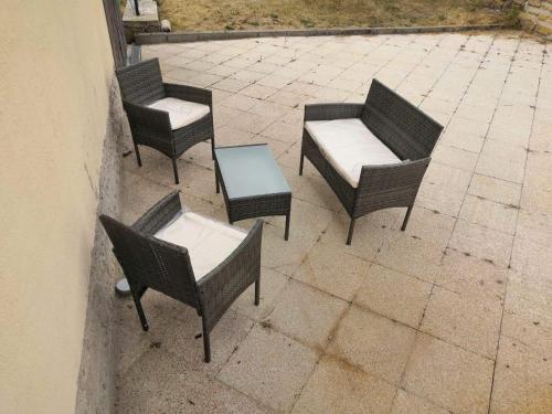 eine Gruppe von Stühlen und Tischen auf einer Terrasse in der Unterkunft Gîte Thomas et Joanie in Moulins-Saint-Hubert